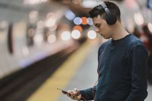 Young man looking at his phone on the subway