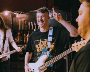 Laughing musician playing guitar in the studio